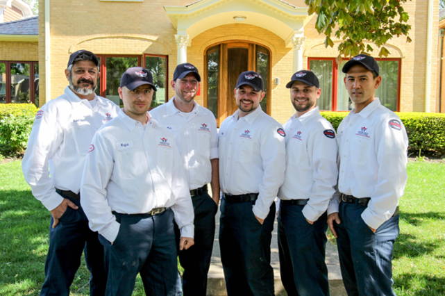 American Vintage Home technicians smiling and standing in front of their office