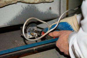 HVAC technician performing furnace maintenance