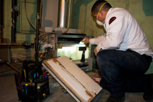 HVAC technician performing furnace maintenance check