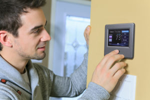 HVAC technician adjusting digital thermostat