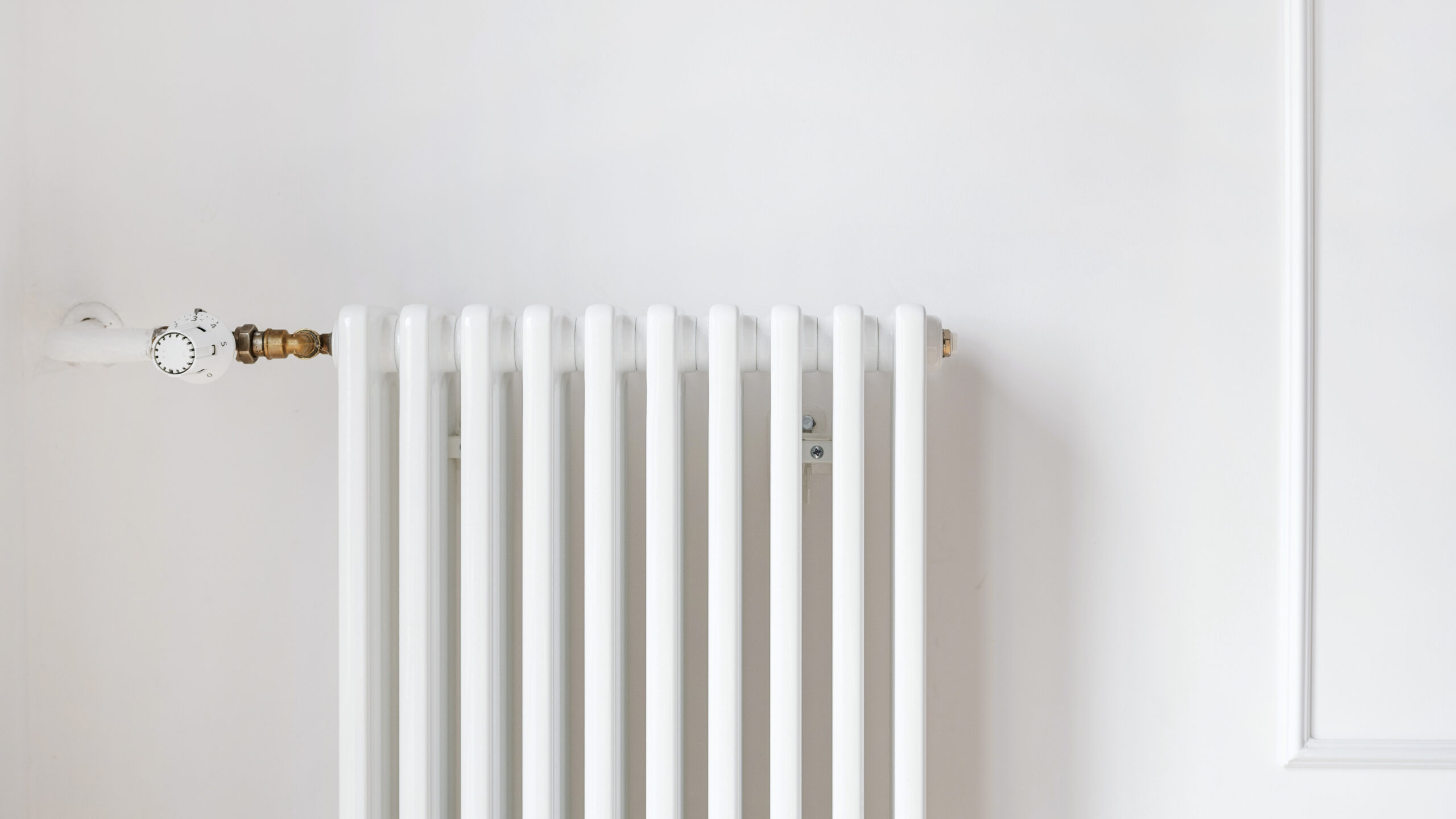 A new white metal radiator, showcasing a simple and functional heating system in a room.