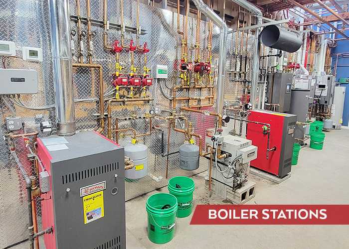 Multiple boiler stations with copper piping installed next to each other for education and comparison by customers