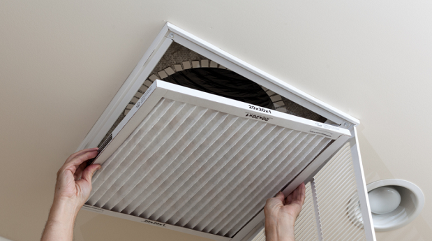 Homeowner changing a dirty air filter