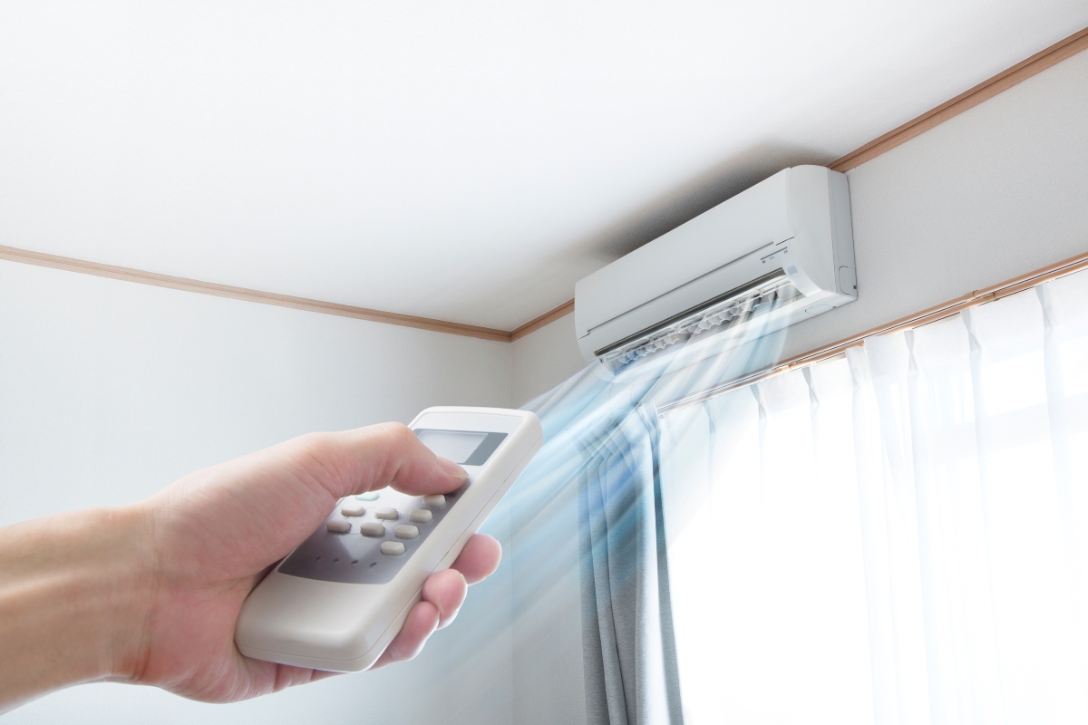 Wall-mounted ductless mini-split being operated with a remote
