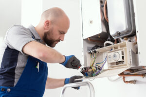Professional qualified technician servicing a natural gas boiler at home